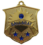 A gold shield-shaped Ballarat medal or pendant with blue accents, including a blue gemstone, blue lettering, and three blue stars, shown on a plain light background.
